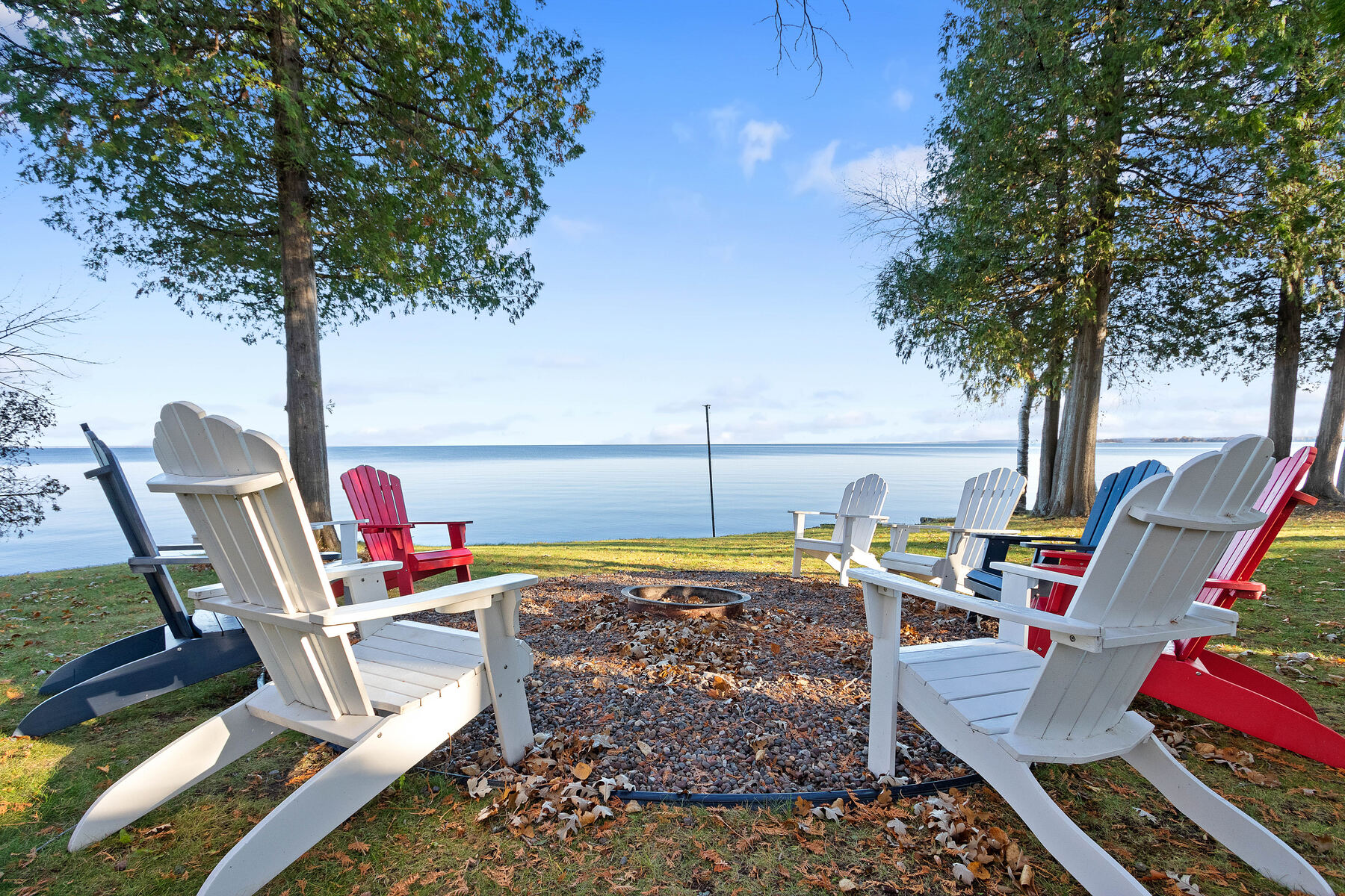 Adirondack chairs around the fire pit at the water's edge
